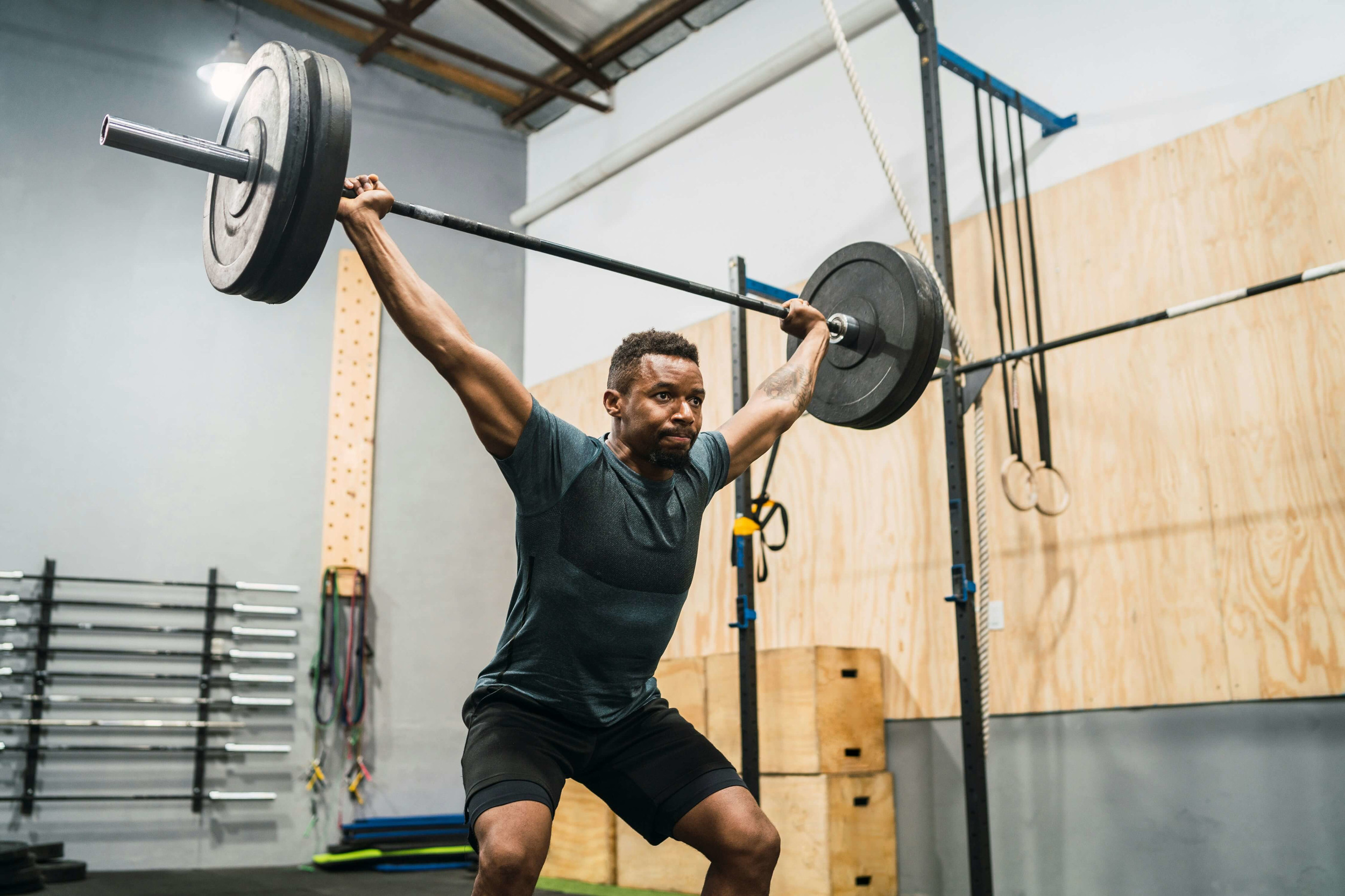 Athlete performing an overhead barbell lift during strength training | Castine Concierge Physical Therapy | Mobile Physical Therapy Services Washington DC